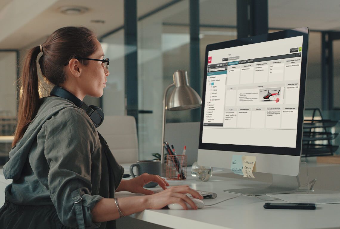 A woman sits at a computer and edits a parameter diagram