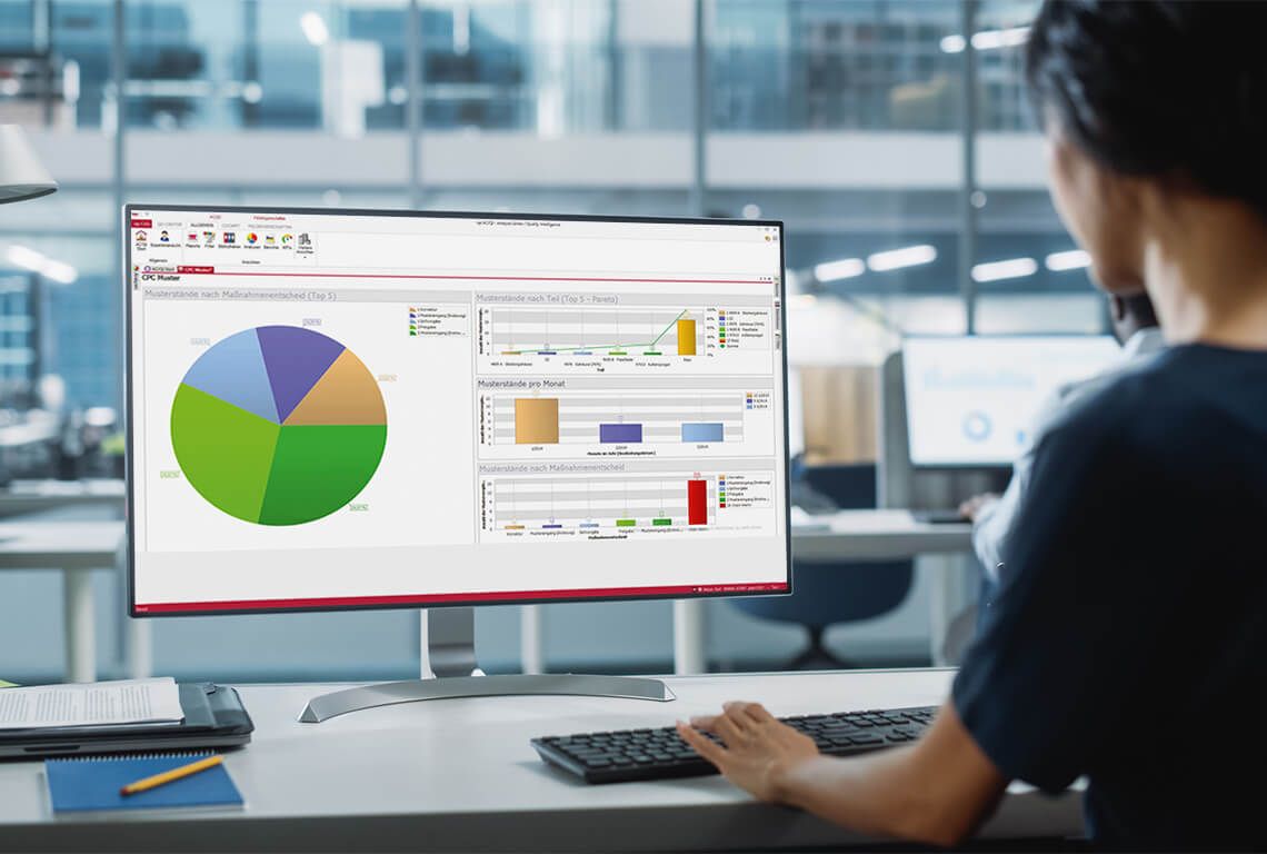 A woman enters quality KPIs on a computer.