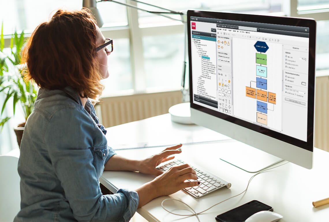 A woman creates a flowchart on a computer.