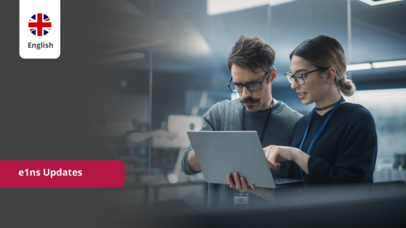 Two professionals discuss the latest e1ns updates on a laptop, covering new features and software improvements.