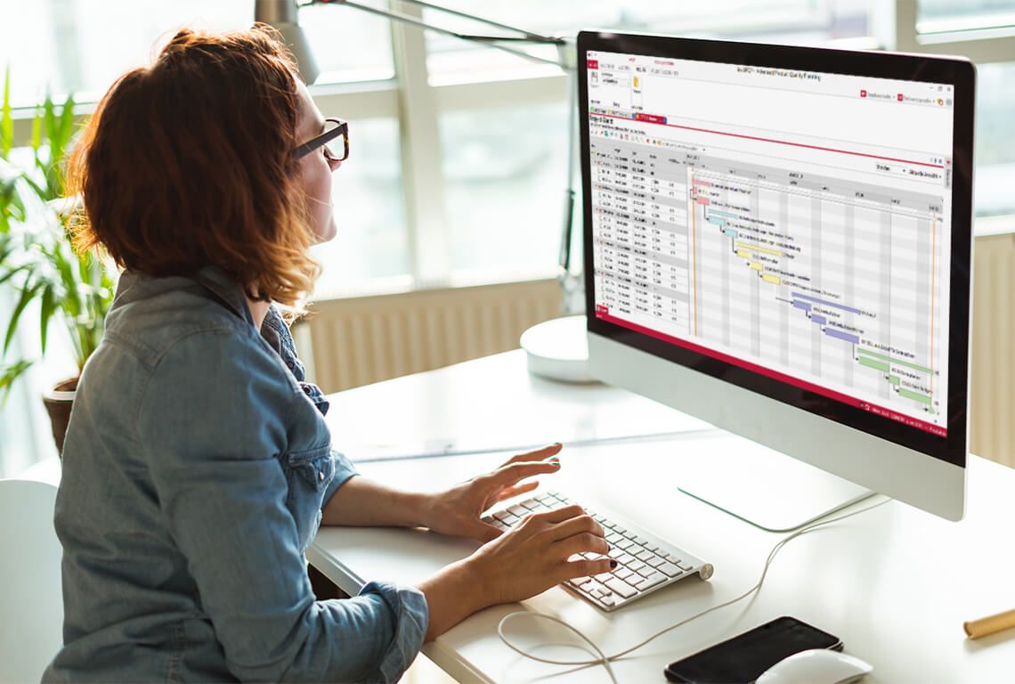 Woman sitting in front of a screen working on an APQP Gantt chart