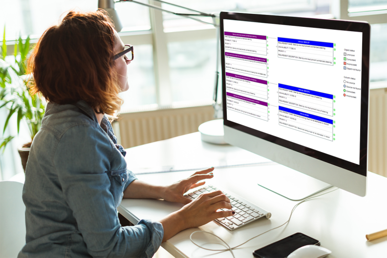 Woman working at a computer displaying the interface between RWB &amp; AttackTree and reqSuite rm