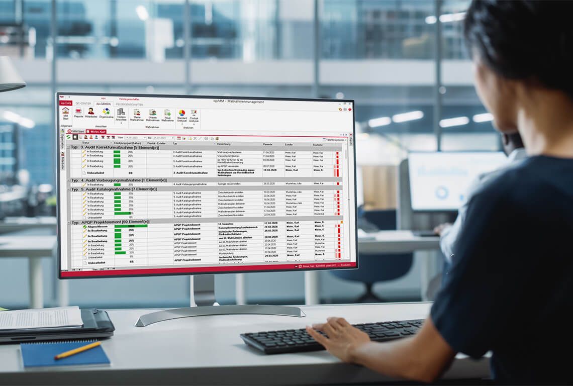 A woman sits in front of the computer and works on her actions.