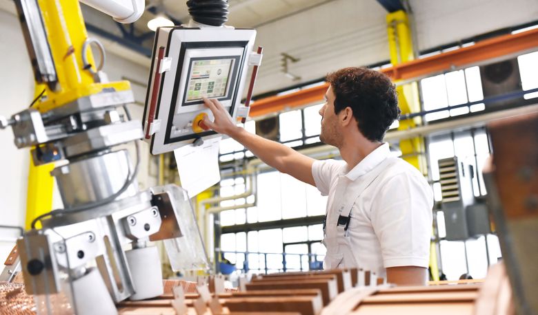 Man operates machine for winding copper wire