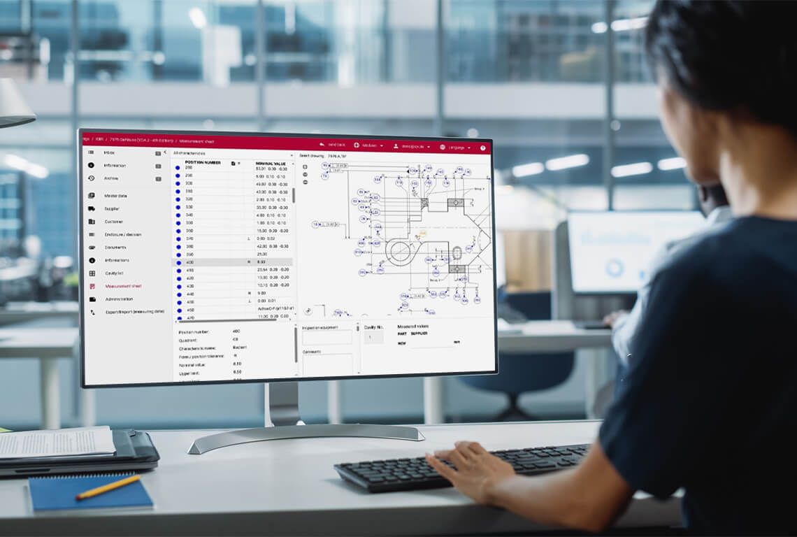 A woman works on an initial sample inspection report on the computer.